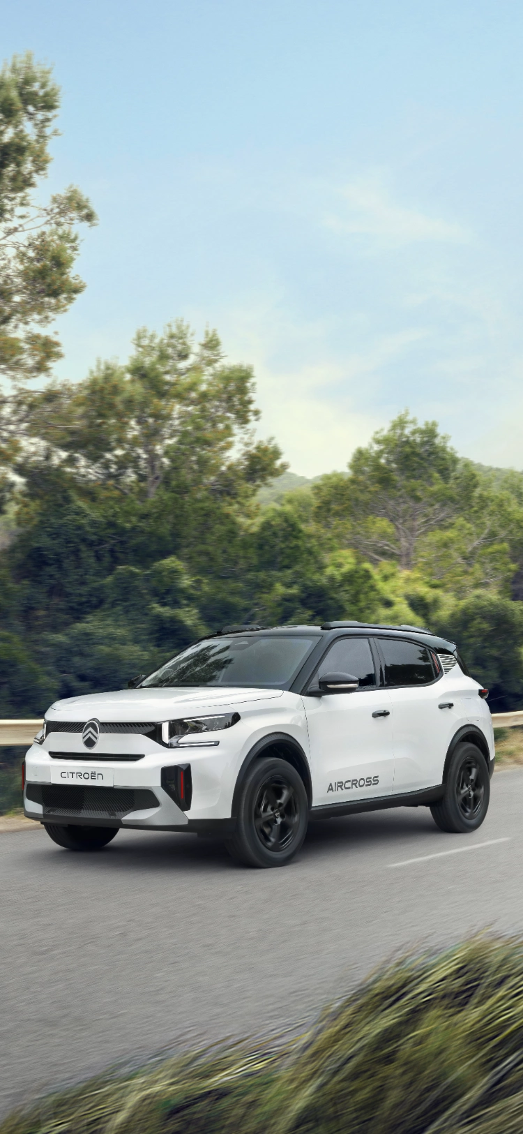 Vista frontale a tre quarti in guida della Citroën ë-C3 Aircross SUV elettrica che mette in evidenza la presenza sicura su strada per una mobilità fluida, efficiente e conveniente.